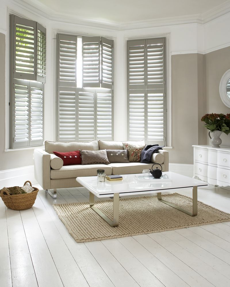 Bright living room with grey bay-window shutters and a cream sofa