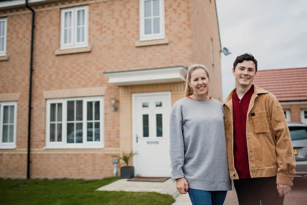 Happy couple outside their new-build home