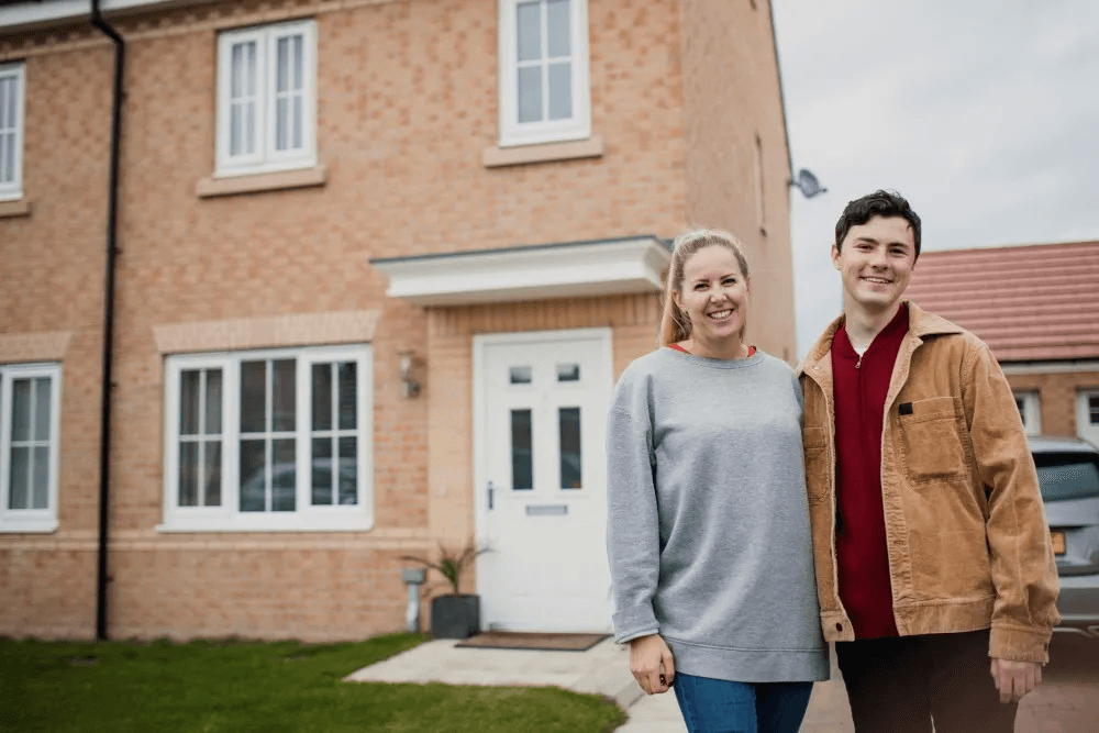 Happy couple outside their new-build home